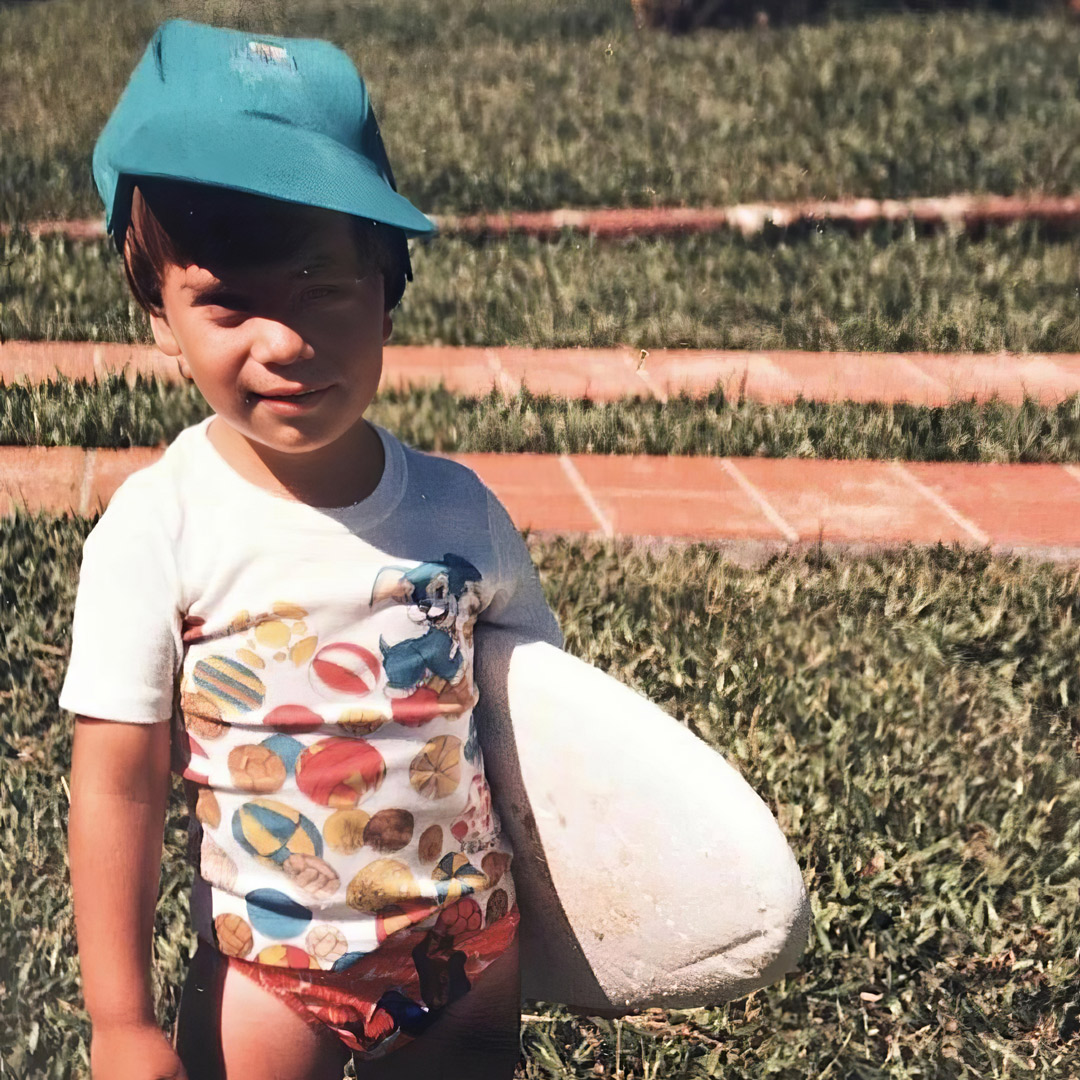 Guilherme Paz na infância, com uma prancha de surf, em 1987